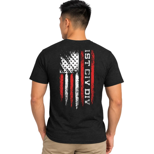 A man viewed from the back wearing a black heather t-shirt with a distressed American flag graphic and the vertical text '1ST CIV DIV' in white and red on the back, paired with khaki pants.