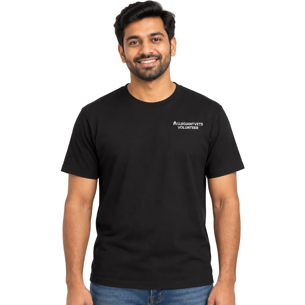 A man wearing a black short-sleeve crewneck t-shirt with a small white 'ALLEGIANTVETS VOLUNTEERS' logo on the left chest, paired with blue jeans, against a plain white background.