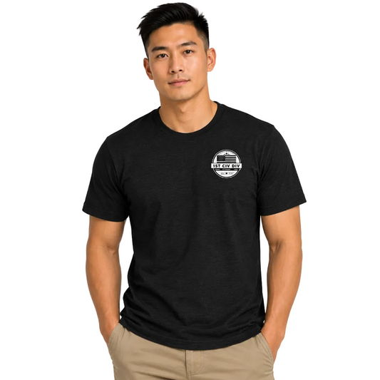 A man wearing a black short-sleeve crewneck t-shirt with a small white circular graphic on the left chest, paired with khaki pants.