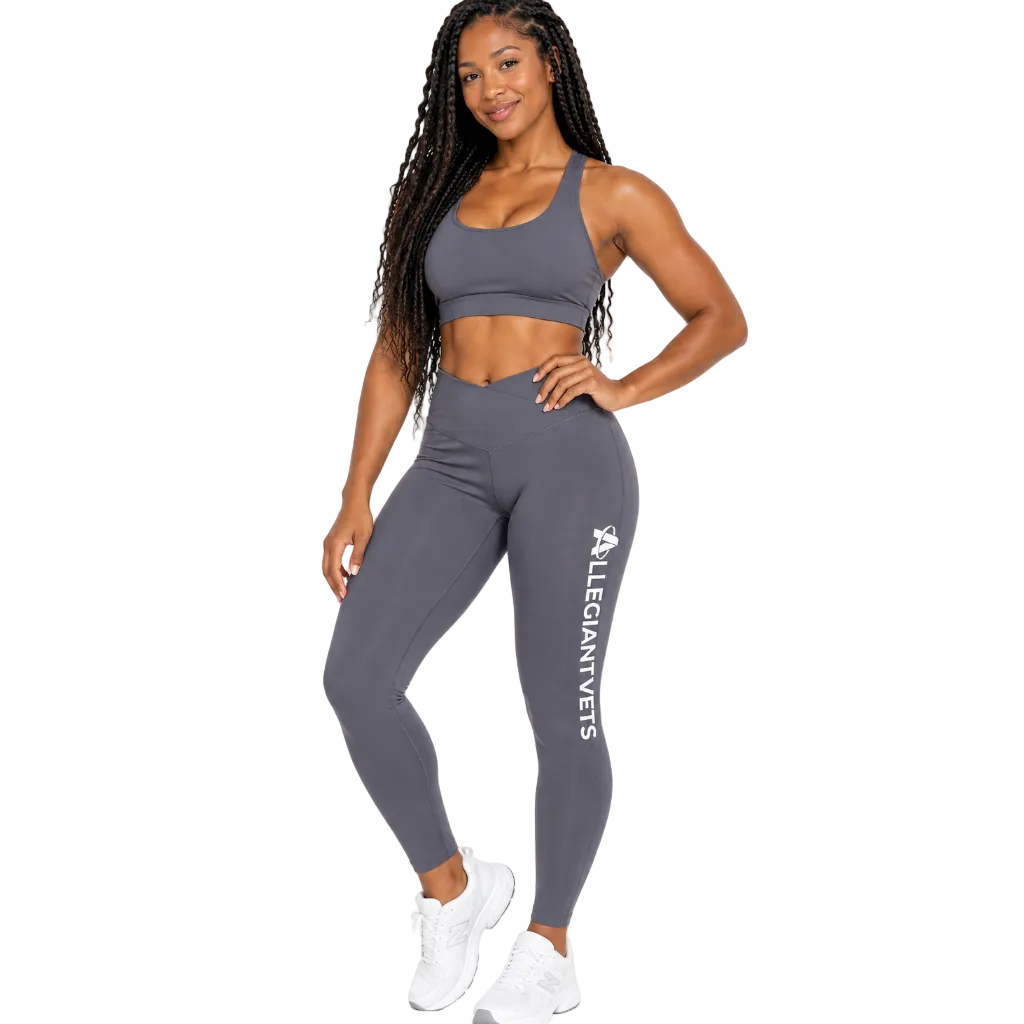 A woman modeling a gray athletic set consisting of a sports bra and high-waisted leggings with 'ALLEGIANTVETS' printed vertically in white on the left leg, posed against a solid white background.
