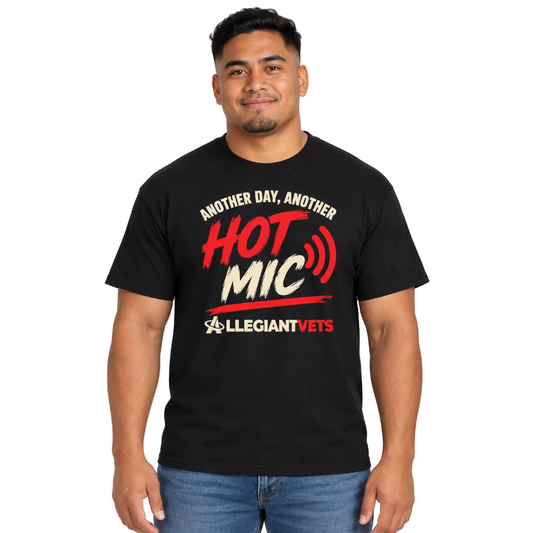 A man wearing a black graphic t-shirt with red and white text that reads 'ANOTHER DAY, ANOTHER HOT MIC' and 'ALLEGIANTVETS'.