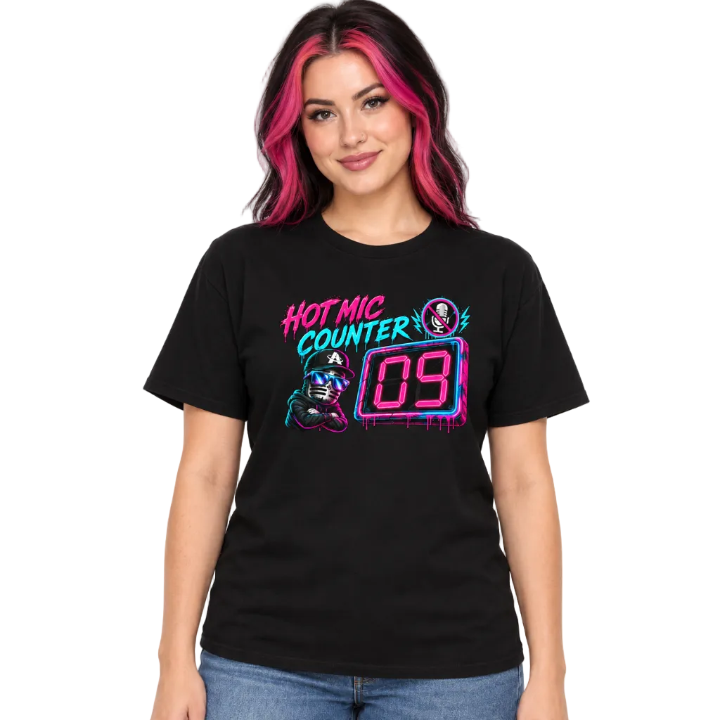 A woman with pink-streaked black hair wearing a black graphic t-shirt with a neon-style 'HOT MIC COUNTER 09' design, paired with blue jeans, against a plain white background.
